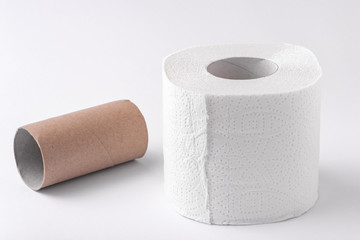 An empty roll of toilet paper and an entire roll isolated on a white background