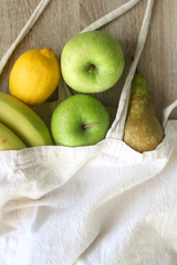 Various fruit in a canvas tote bag. Selective focus.