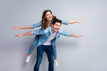 I will show you sky. Portrait of positive cheerful man hold his girlfriend piggyback imagine fly...