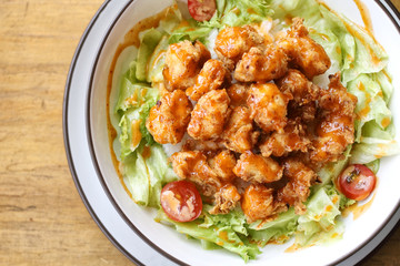 a bowl rice with topping fillet chicken and vegetable