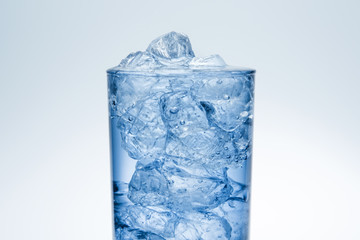 Close-up of a glass transparent glass filled with ice and water.