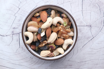 Mixed nuts in wooden bowls on wooden table .