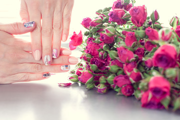 Female hands with art nail manicure and small pink roses
