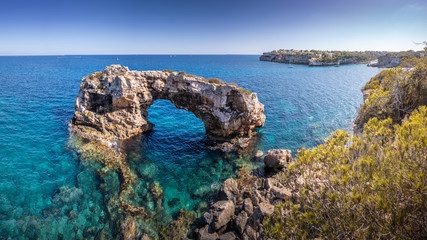 Blue water and sunny day at the Beautiful nature wonder in Palma de Mallorca. Es Pontas natural rock formations in Palma de Mallorca, Balearic Islands