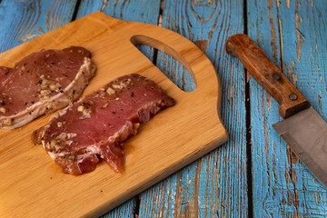 aw pork tenderloin marinated in black pepper on wooden cutting board