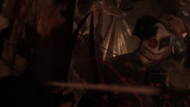 A scarier clown with knife at crude basement with a mirror on the wall