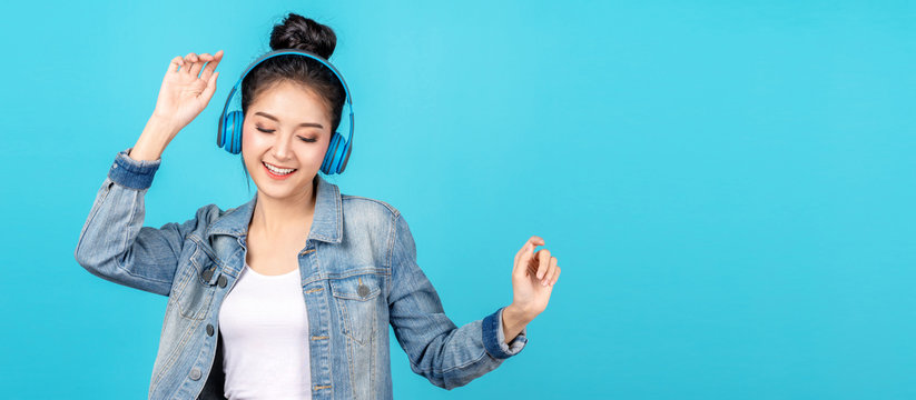Young happy attractive asian woman using headphone enjoy listen to song in concept of next normal life, pastime or hobby online. Quarantine activity asian lifestyle listening to music on radio online.