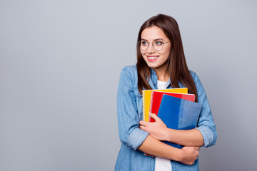 Smart clever intelligent dreamy girl high school student hold note books look copyspace dream she pass her graduation A exam wear casual style outfit spectacles isolated gray color background