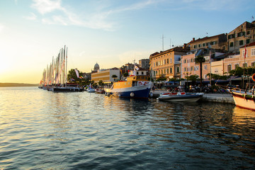 Obraz premium Waterfront promenade of Šibenik in Croatia along the Adriatic Sea, at sunset - Medieval buildings on the hill of this historical town
