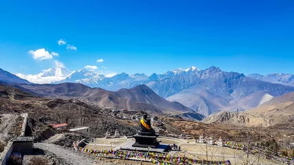 Photo sur Plexiglas Manaslu A complex of Buddhist temples in Muktinath, along Annapurna Circuit Trek in Nepal. The temple is richly ornated with gold. In the back there is a high, snow capped Himalayan chain. Spirituality