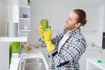 Profile side view portrait of his he nice attractive cheerful cheery guy husband cleansing things furniture washing cleaning service in modern light white interior style kitchen