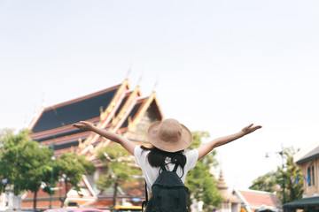 Rear view of young asian girl open arms to historical landmark. Bangkok, Thailand.