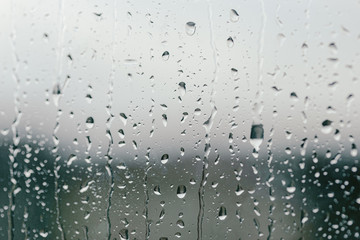 Rain drops on the window. Spring thunderstorm in April, May. Summer thunder. Summertime sadness, melancholy blues. Macro rain drops. Bokeh effect. Calmess and relaxation. Cloudy weather. Autumn day.