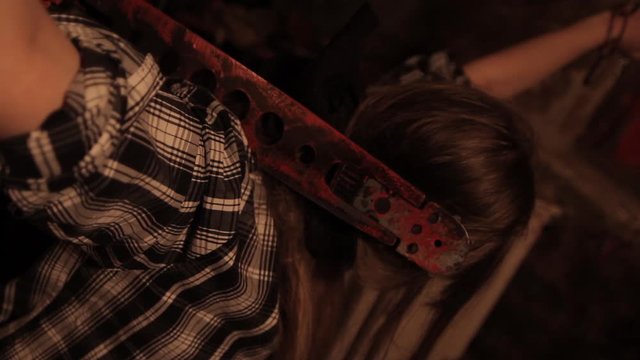 Silhouette of man maniac or killer or horror murderer with chainsaw in hand in dark creepy and spooky room. Criminal robber or rapist concept in thriller atmosphere with  victim girl