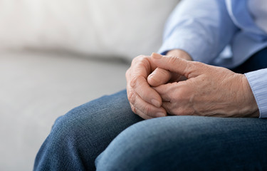 Aging And Retirement. Closeup Of Hands Of Senior Woman Sitting On Couch