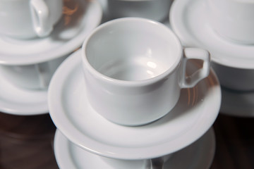 dirty coffee cup and spoon setting on white saucer and wooden table after drinking in the morning in vintage style.