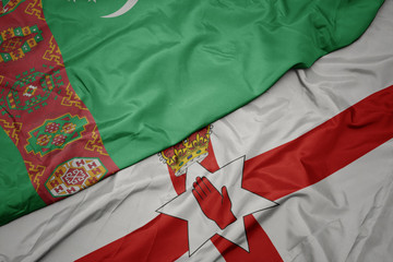 waving colorful flag of northern ireland and national flag of turkmenistan.