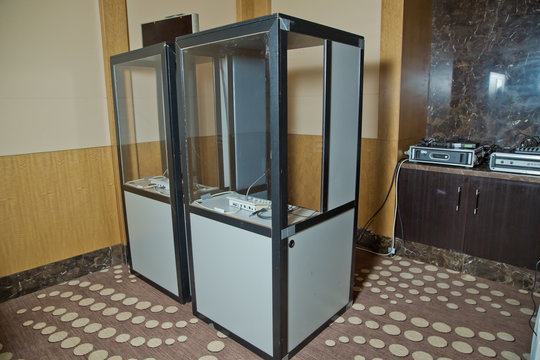 Soft focus of wireless Conference microphones and notebook in a meeting room. translators cubicle . interpreting - Microphone and switchboard in an simultaneous interpreter booth .