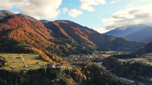 Dolly out by Drone shot of Aerial view over historical village-go village in the autumn during sunset,  Shirakawa-go is one of Japan's UNESCO World Heritage Sites. The traditionally thatched houses.