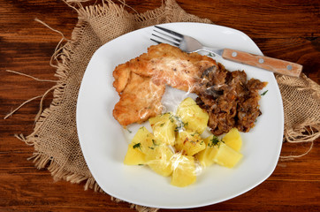 boiled potatoes with fried cabbage, sprinkled with dill, chicken cutlet, traditional Polish dish