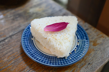 Jasmine rice served as a triangle topped with Orchid petals.
