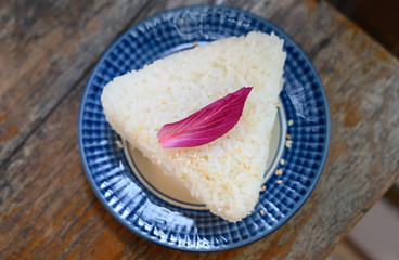 Jasmine rice served as a triangle topped with Orchid petals.