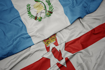 waving colorful flag of northern ireland and national flag of guatemala.