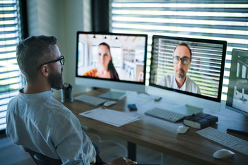 Businessman with computer sitting at desk, working. Business call concept.