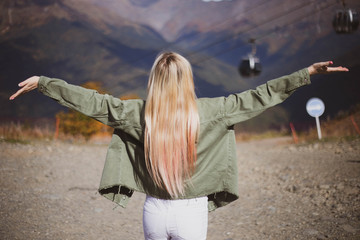 Blonde girl beautiful long-haired traveling in the mountains.