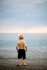 A small boy a handsome blond runs to the Black sea.A small boy a handsome blond runs to the Black sea.