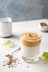 Dalgona Coffee, a cool fluffy whipped coffee in a glass. Latte espresso with coffee foam in tall glass. Trendy drink