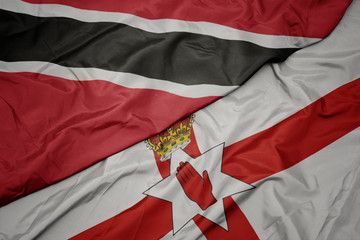 waving colorful flag of northern ireland and national flag of trinidad and tobago.