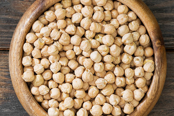 Chickpeas in a wooden bowl on a wooden table. Top view 