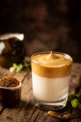 Dalgona Coffee, a cool fluffy whipped coffee in a glass. Latte espresso with coffee foam in tall glass. Trendy drink
