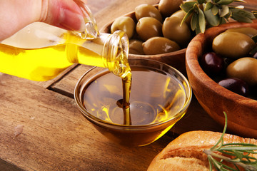 Olives. Bottle virgin olive oil and oil in a bowl with some green and black olives