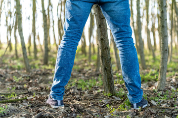man peeing on a tree in the woods
