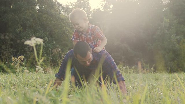 dad and son happy family play push ups slow motion funny video. father man lifestyle and son little a boy push ups in nature laugh and play