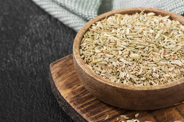 Dried fennel in a wooden bowl on the black kitchen table