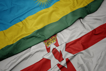 waving colorful flag of northern ireland and national flag of rwanda.