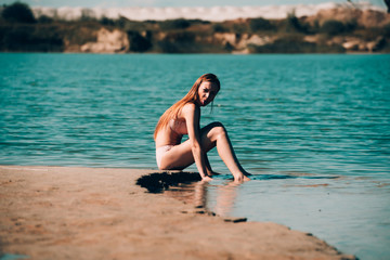 Woman in underwear lying and tanning on a sandy beach on sea background. Relax and leisure at the seaside, sunburn, holiday and vacation concept