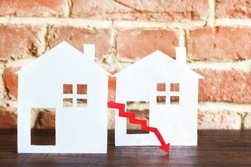 White houses with red arrow showing down. Real estate market rate down.