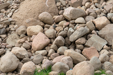 a pile or pile of rocks on the beach. A lot of big stones.
