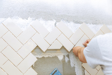 The hands of laying the tiles the ceramic tile