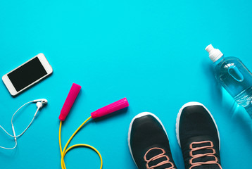 Flat lay photo of fitness equipment over turquoise blue backgound.Workout objects with  top view  and copy space. 