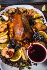 baked goose chicken with apples and orange on a festive table a restaurant dish on a wood background