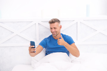 Modern life. Cellular communication. Communication technology. Self isolation and quarantine. Stay home. Morning. Online communication. Mature man use mobile phone in bed. Mobile communication