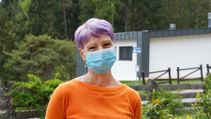 Coronavirus. COVID-19. Woman at home, in her garden, during quarantine with mask protection. Stay at home activities. Prevent infection from the pandemia. Social distancing. Confinement. 