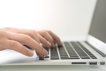 Hands writing on a Keyboard of a Laptop or Notebook in Home Office