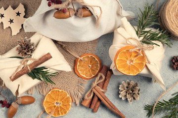 Zero waste christmas concept. Packed in natural fabric gifts and decorations from natural materials on gray table, top view