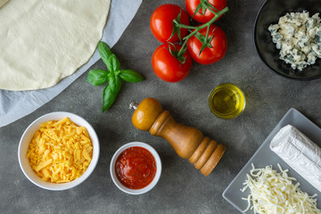 Ingredients for four cheese pizza on the table. Making vegetarian lunch or dinner.  Top view. 